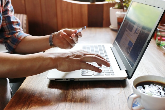 Women touching screen and man typing laptop on wood table