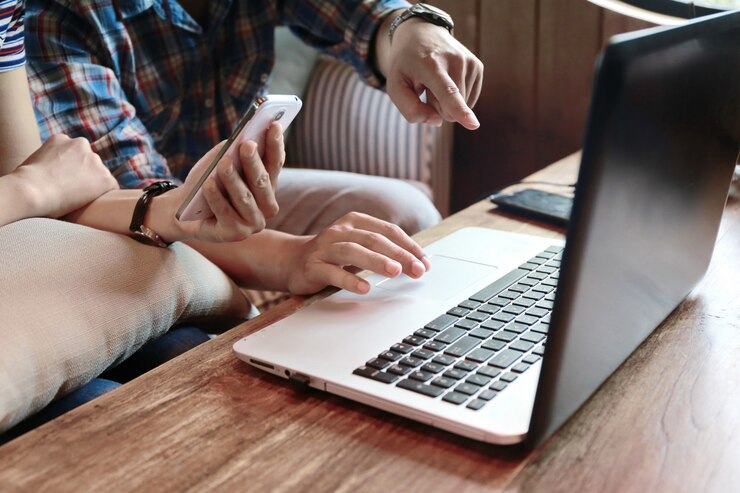 Photo women touching screen and man typing laptop on wood table