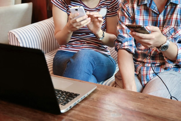 Photo women touching screen and man typing laptop on wood table