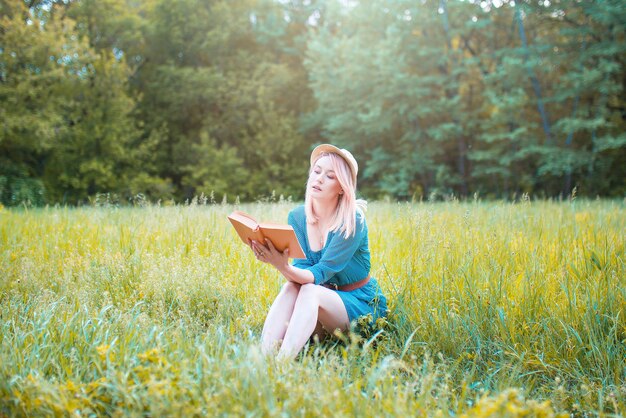 女性観光客は穏やかな自然の中で本を読みます。