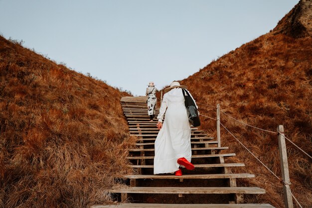 Women tourists walking on wooden stairs at Padar island Labuan Bajo