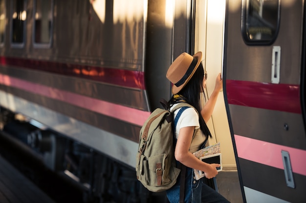 女性は夏の旅行のために鉄道駅で旅行する、旅行のアイデア。