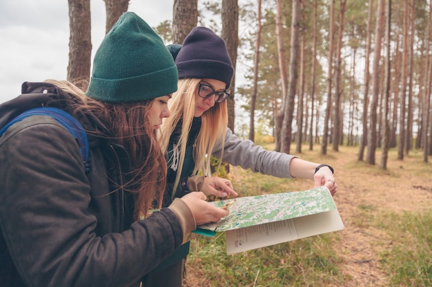 Women travelers with the map and compass