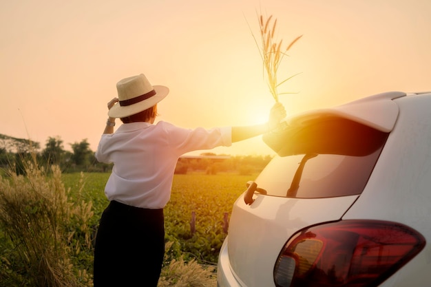 Women traveling alone concept Women are relaxing outside of the white car and looking at the beautiful nature She is learning new things in life