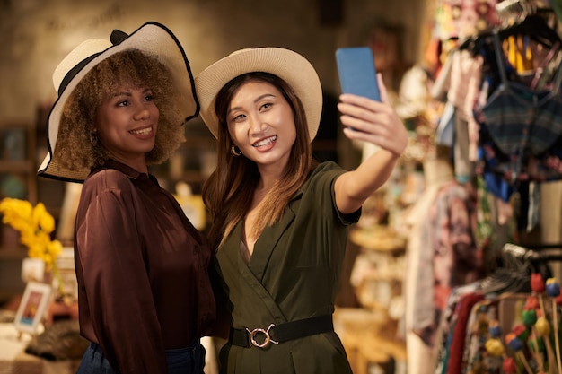 Donne che provano cappelli di paglia