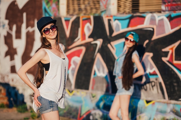 Women at urban graffiti wall