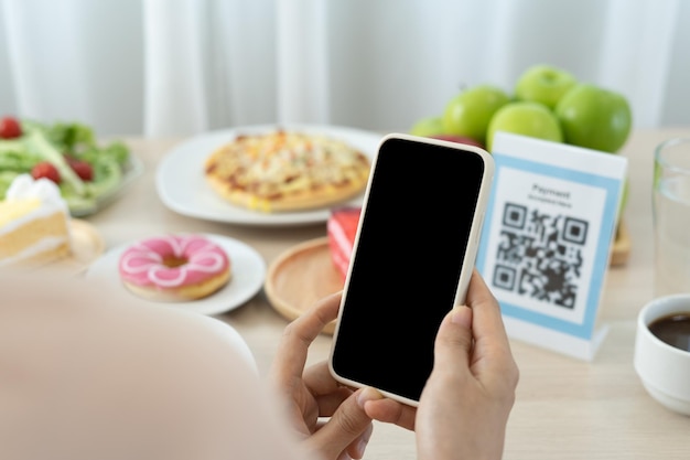 Women use phone to scan qr code to select food menu and collect
points scan to get discounts or pay for food the concept of using a
phone to transfer money or paying money online without cash