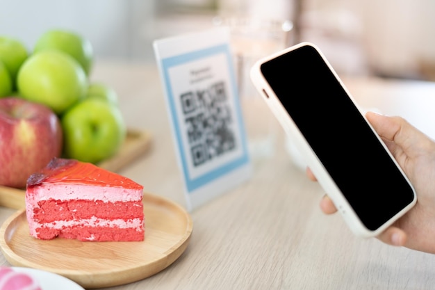 Women use phone to scan qr code to select food menu and collect\
points scan to get discounts or pay for food the concept of using a\
phone to transfer money or paying money online without cash