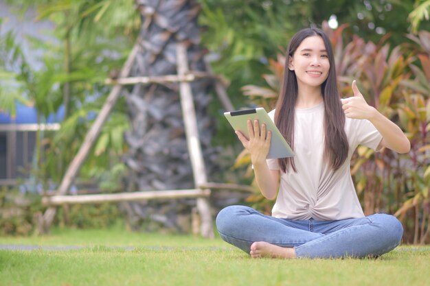 Women use tablet shopping online sitting city park