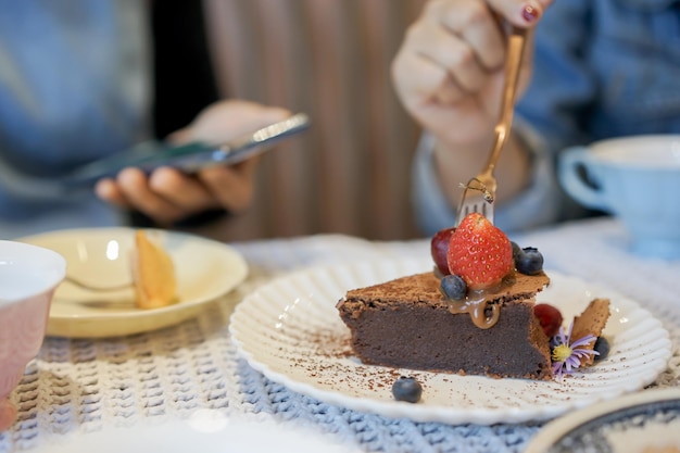 Photo women using fork for eating beauty homemade cake