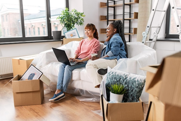 women using laptop and moving to new home