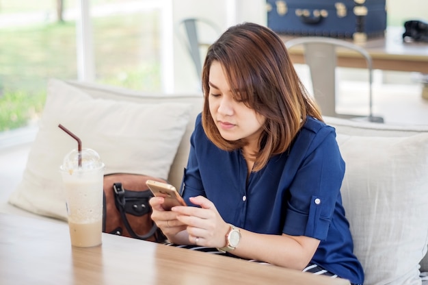 Women using a smartphone in a shop, soft focus.