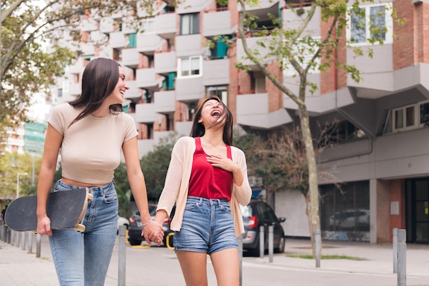 Women walking holding hands through the city