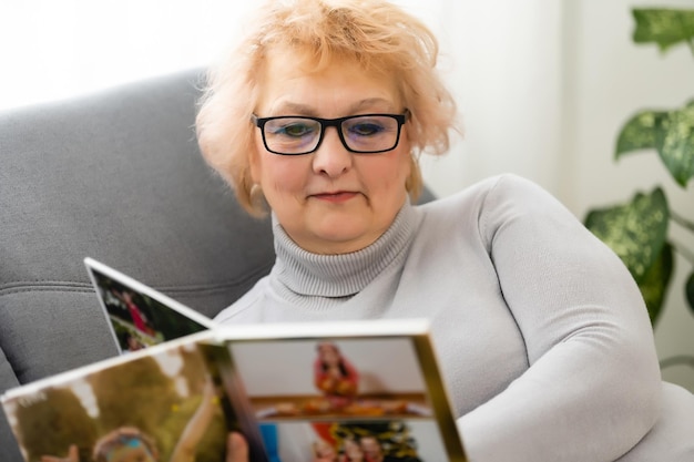 Donne che guardano l'album di famiglia a casa, donna anziana che guarda il fotolibro