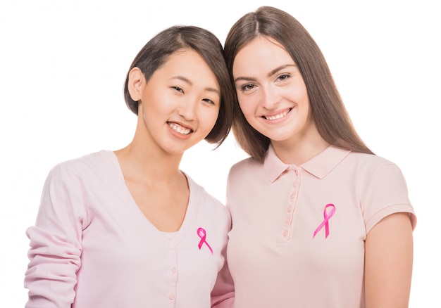 Women wearing pink tops and ribbons for breast cancer.