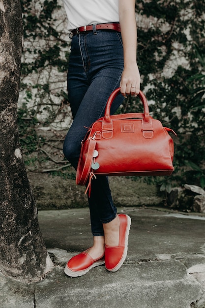 Women wearing sandals or shoes holding a wallet, purse and bag