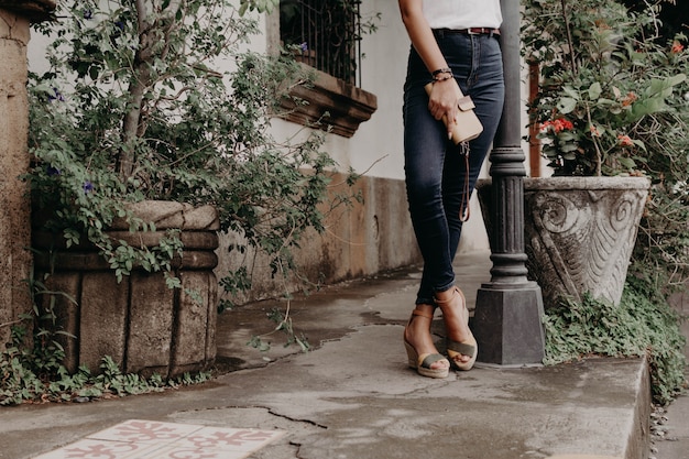 Women wearing sandals or shoes holding a wallet, purse and bag