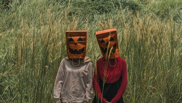 Photo women wearing shopping bags on head while standing on field