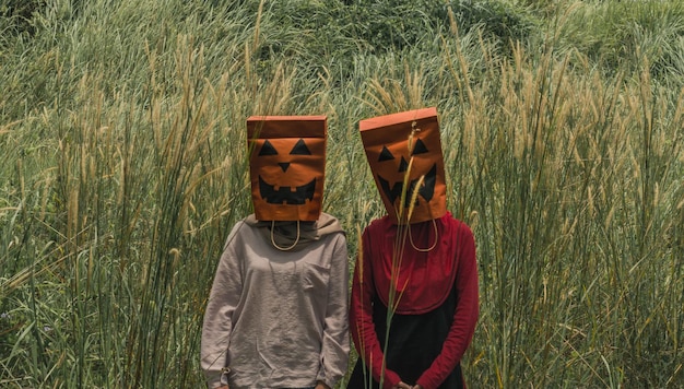 Фото Женщины, носящие сумки с покупками на голове, стоя на поле