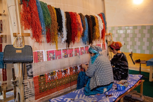 女性たちはペアでカーペットを織ります