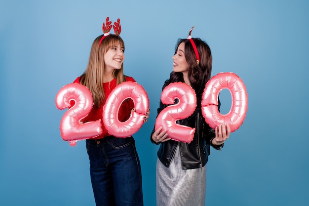 Women with new year balloons wearing funny christmas hoops