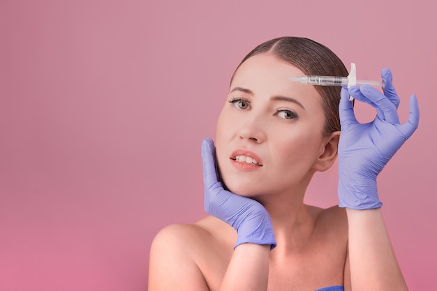 Women with perfect skin posing holds a syringe in their hand