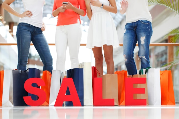 Photo women with red sale letters in mall shopping concept