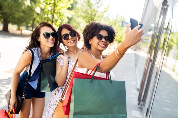 Foto donne con le borse della spesa che si fanno un selfie in città