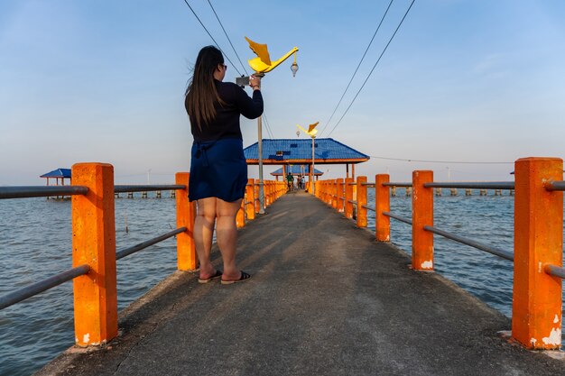 海の自然の中で携帯電話のスマートフォンを持つ女性