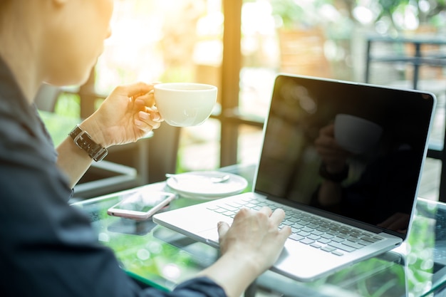 女性はオフィスのコンピュータで働く。