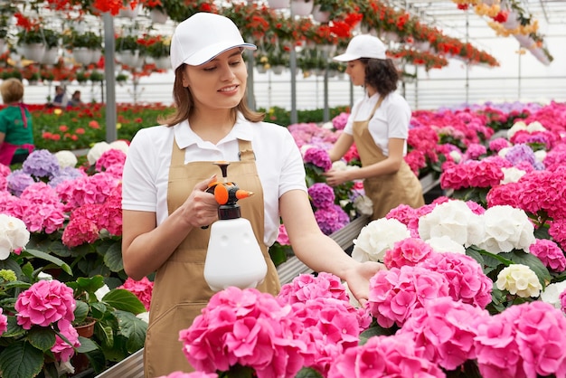 植物に給餌し、水をまく女性労働者