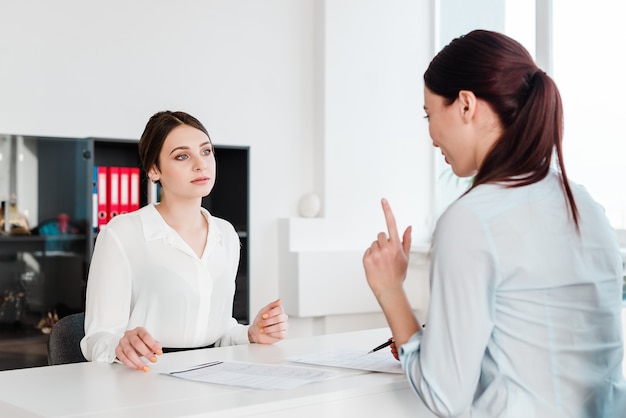 Women working in the office signing papers and discussing business