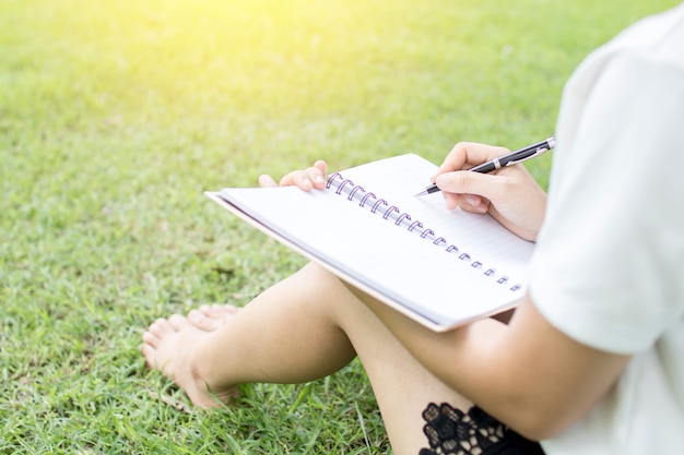 women writing on green grass