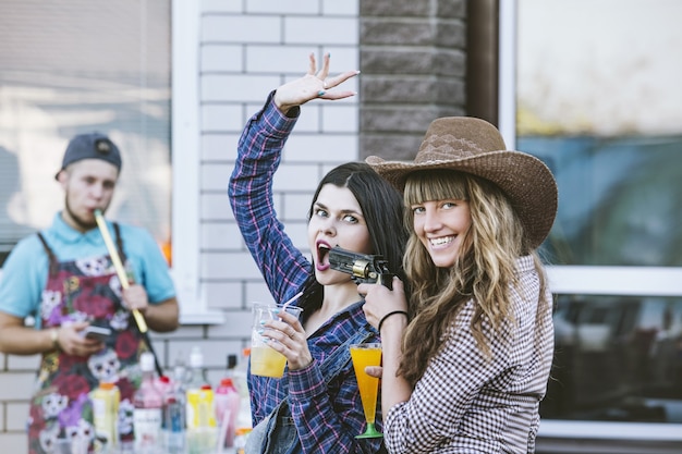 Foto donne giovani e belle divertimento sensuale a una festa con bevande insieme in stile cowboy