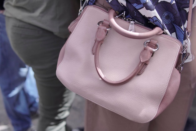 Women39s handbag in pink leather in exterior with people