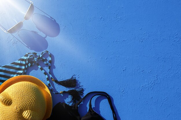 Womens accessories for a beach holiday on a blue background the concept of a trip to the sea