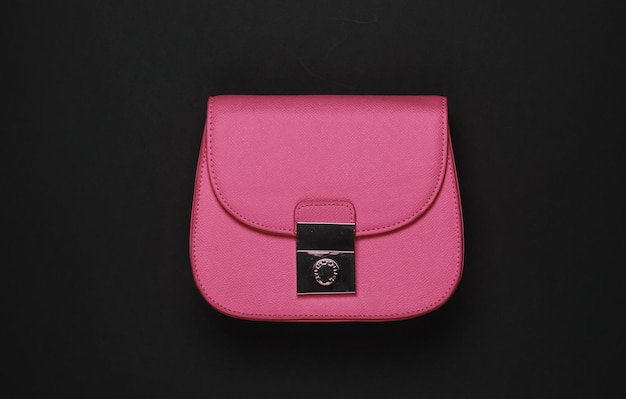 Womens accessories Leather pink bag on a black background Top view