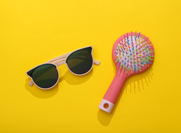 女性用アクセサリー 黄色い背景のヘアブラシ付きサングラス トップビュー