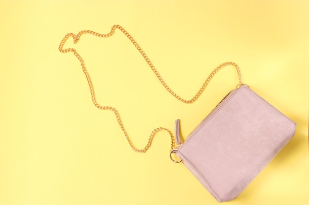 Womens bag and cosmetics on a colored background