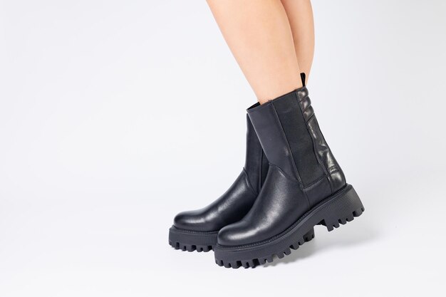 Womens black spring boots made of genuine leather are dressed on bare feet