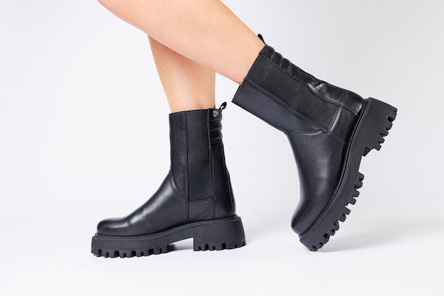 Womens black spring boots made of genuine leather are dressed on bare feet