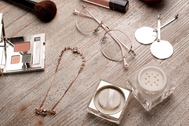 womens cosmetics and accessories on a wooden table