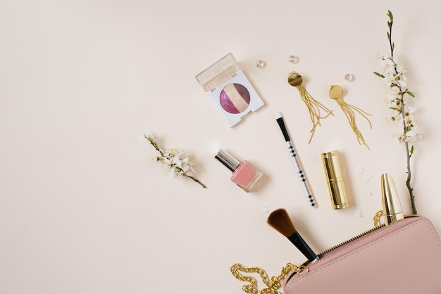 Womens desk with cosmetics which lies next to a pink bag or cosmetic bag with copying space