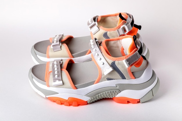 Womens fashionable sports sandals with orange accents on a white background