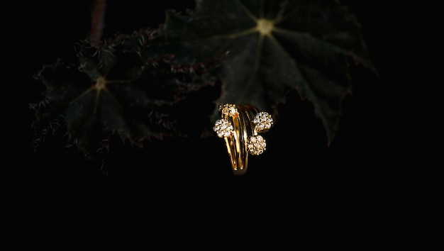 женский золотой браслет с круглыми драгоценными камнями на черном фоне