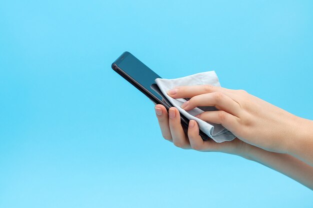 Womens hands are wiping a mobile phone