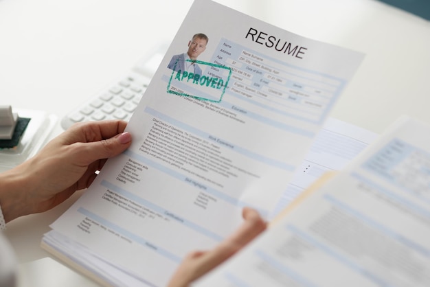 Womens hands hold a resume of a man closeup