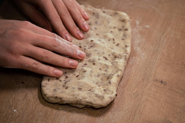 Photo womens hands roll out dough from whole grain flour making homemade bread