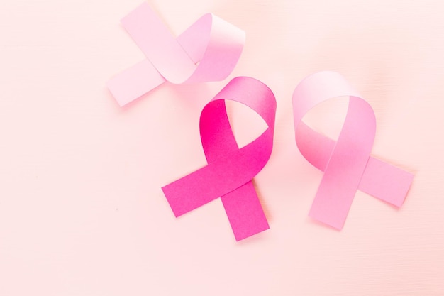 Womens health symbol in pink ribbon on a pink background.