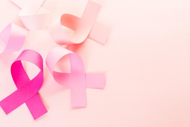 Photo womens health symbol in pink ribbon on a pink background.